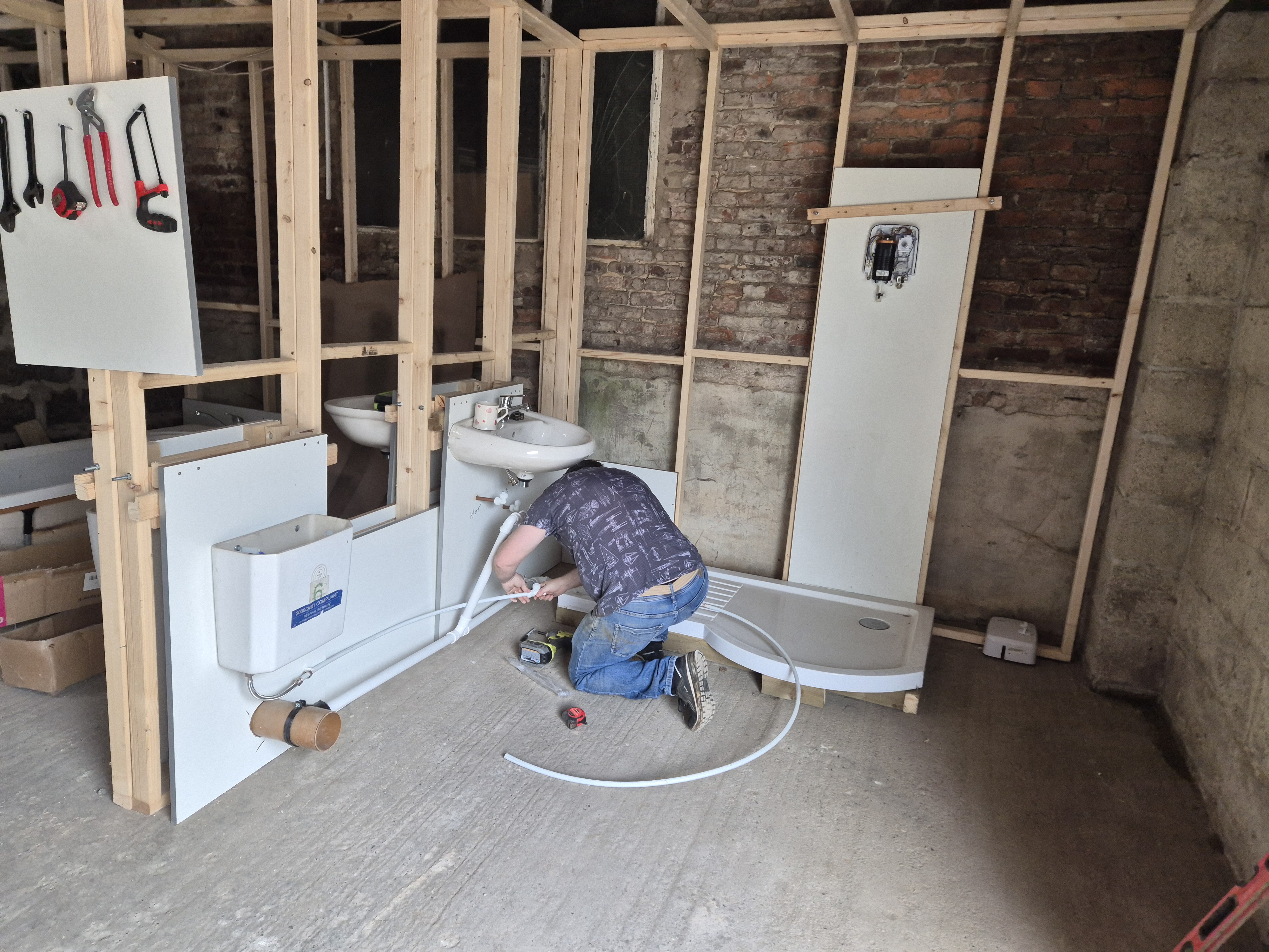 Learner fitting plasterboard panels during practical bathroom training